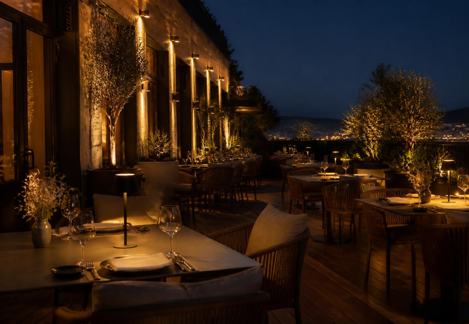 Terras met warme buitenverlichting, tafellampen en aangelichte gevel
